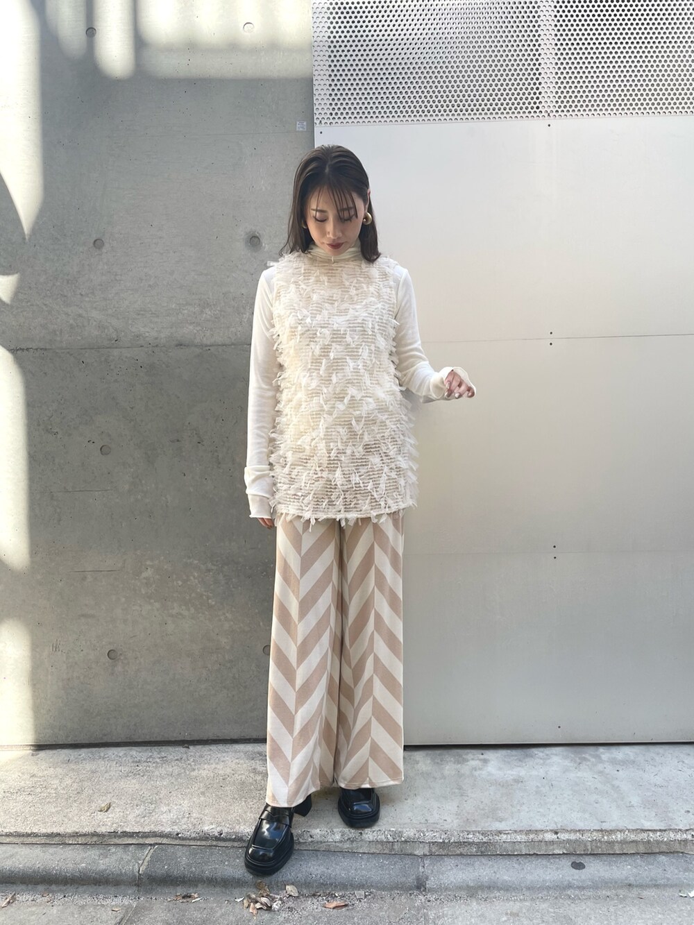 ホワイト系のTシャツ/カットソー、ホワイト系のベスト、ベージュ系のその他パンツを着用したレディースの春コーディネートの2枚目の写真