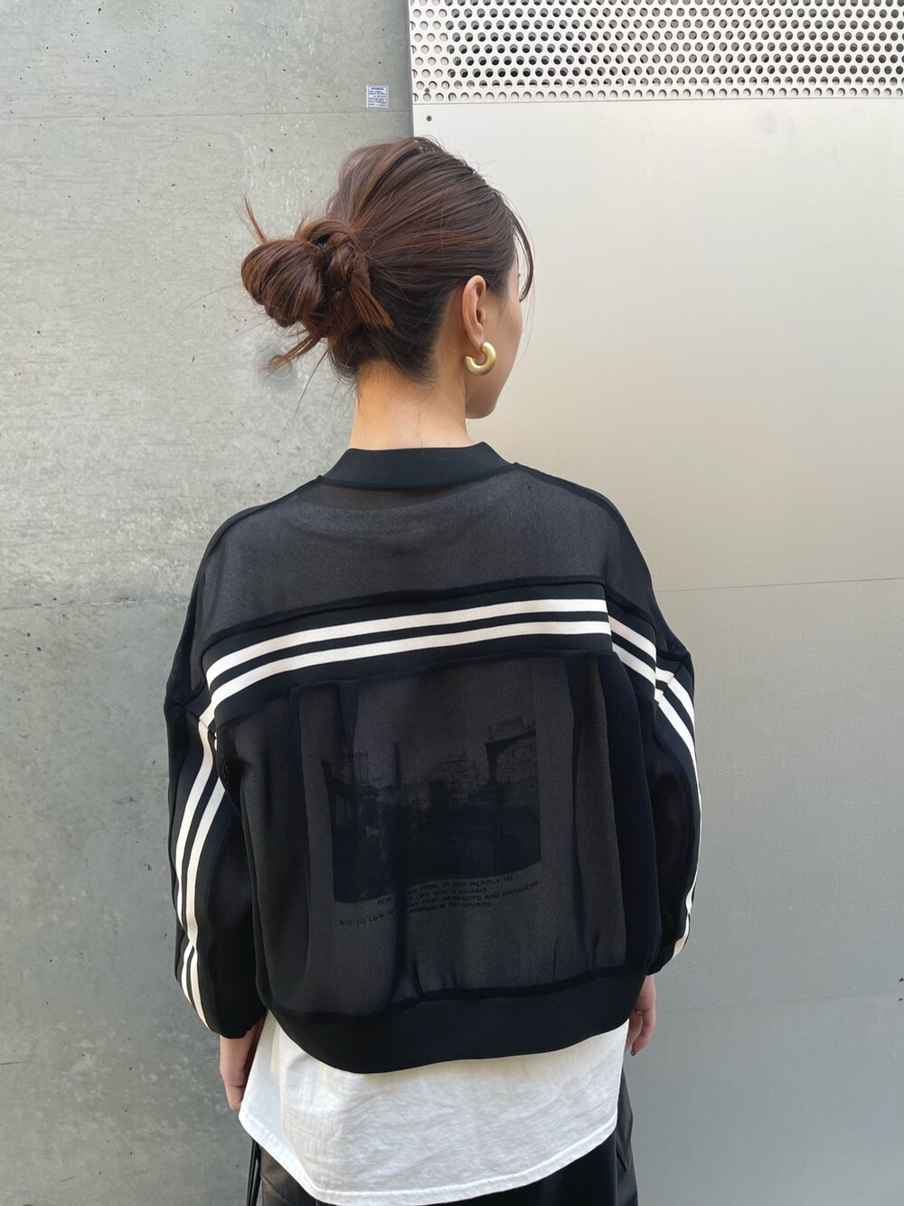 ブラック系のショルダーバッグ、ブラック系のスカート、ブラック系のブルゾンを着用したレディースの春コーディネートの4枚目の写真