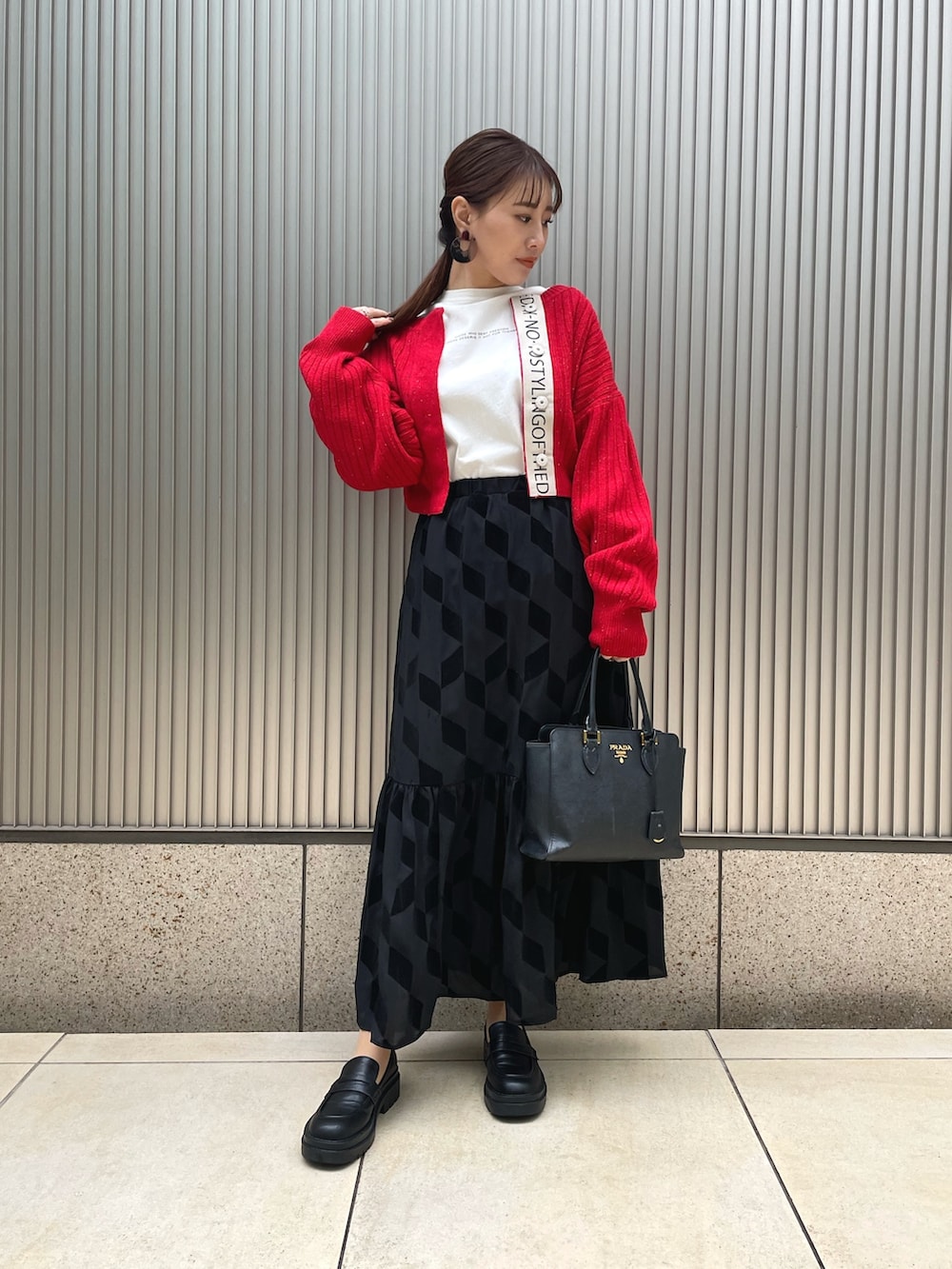 ブラック系のバッグ、ブラック系のスカート、レッド系のカーディガン/ボレロを着用したレディースの冬コーディネートの2枚目の写真