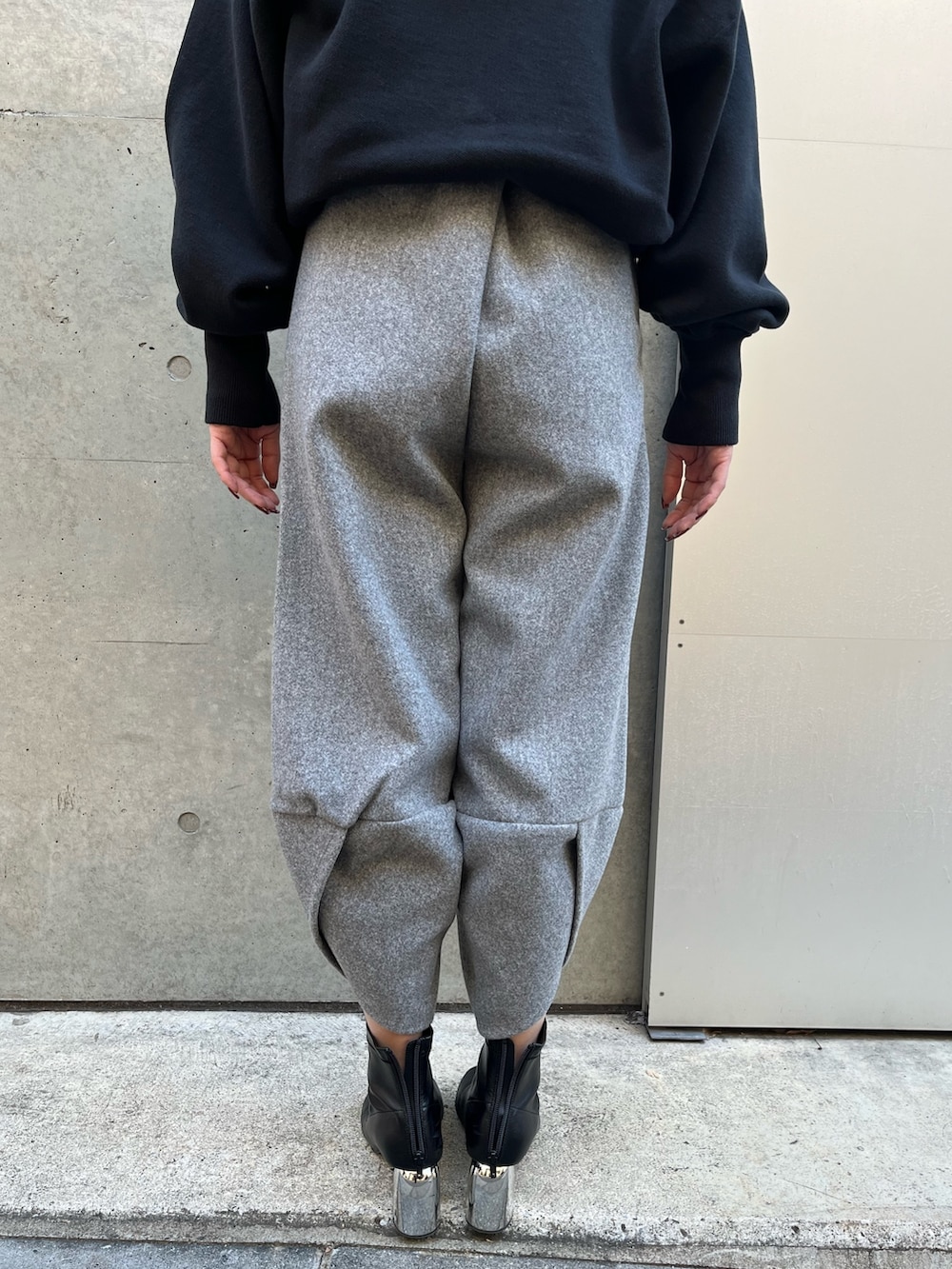 グレー系のその他パンツ、ブラック系のニット/セーター、ブラック系のハットを着用したレディースの冬コーディネートの5枚目の写真