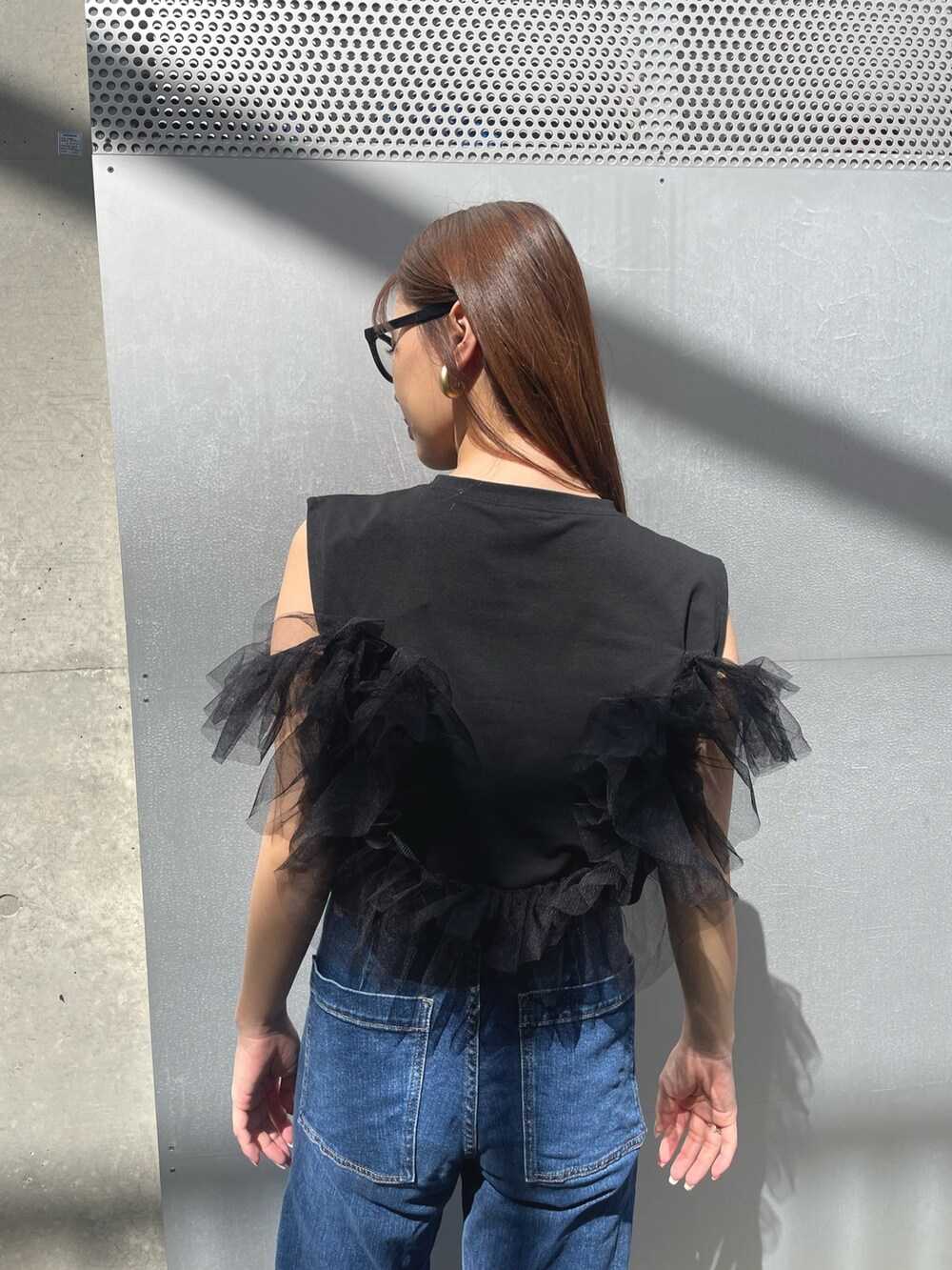 ブラック系のローファー、ブルー系のデニムパンツ、その他のサングラスを着用したレディースの春コーディネートの3枚目の写真