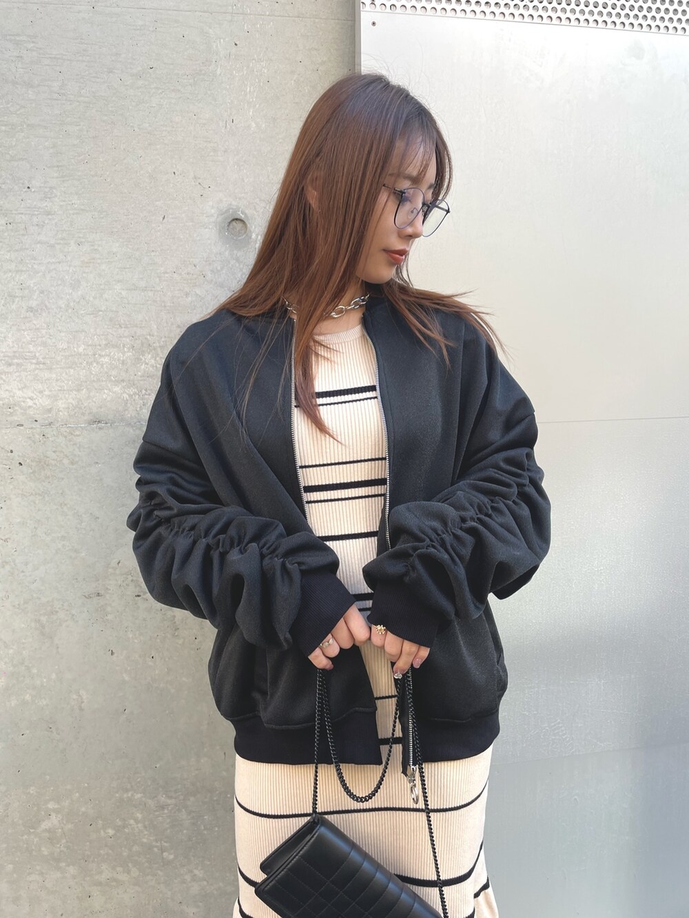 ブラック系のショルダーバッグ、ブラック系のブルゾンを着用したレディースの冬コーディネートの3枚目の写真