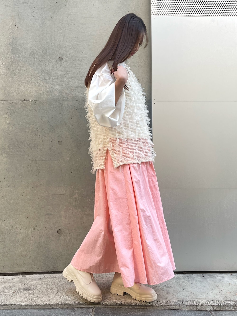 ピンク系のスカート、ホワイト系のシャツ/ブラウス、ホワイト系のベストを着用したレディースの冬コーディネートの3枚目の写真