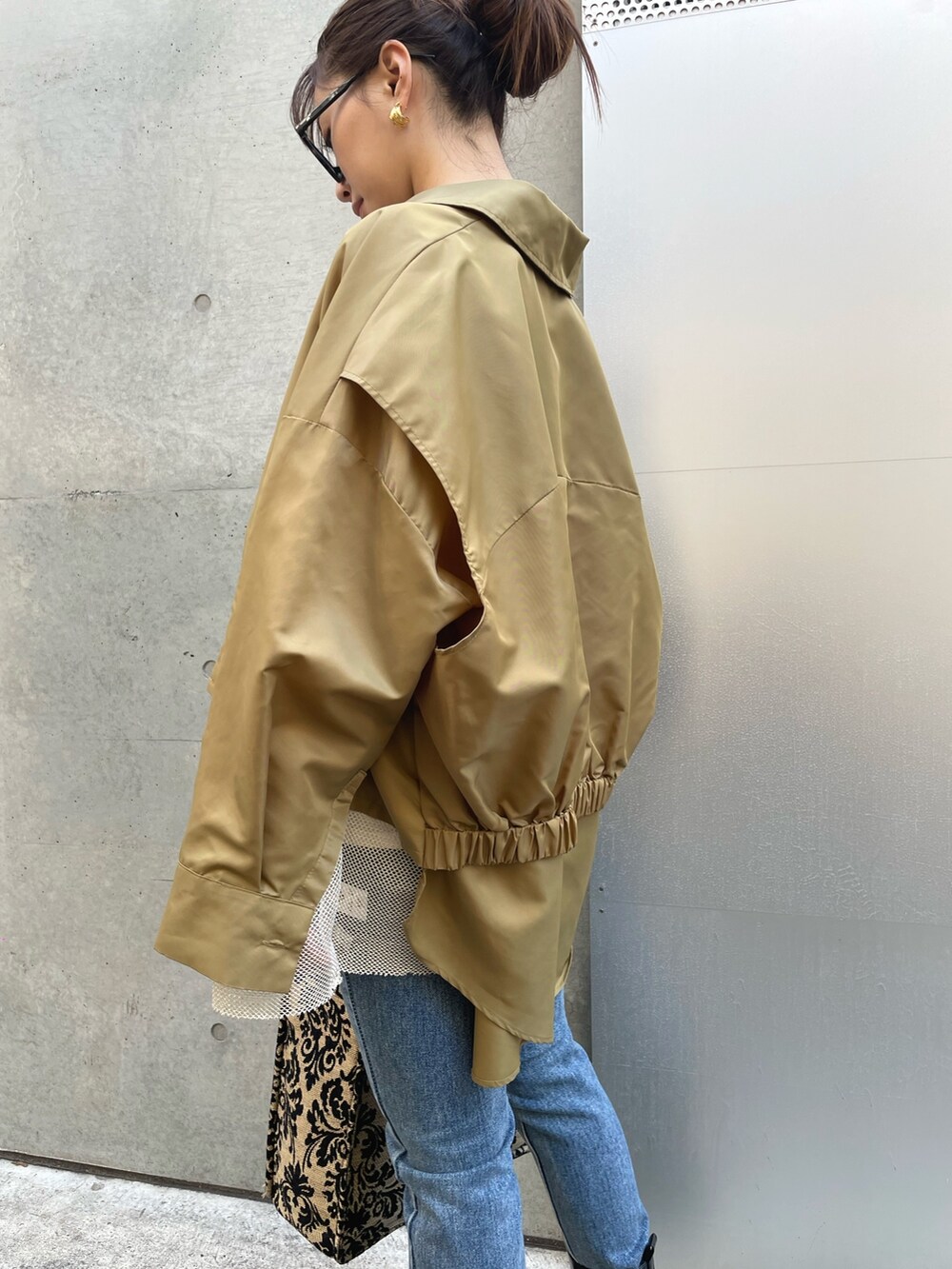 ホワイト系のTシャツ/カットソー、ブルー系のデニムパンツ、ブラック系のブーツを着用したレディースの冬コーディネートの4枚目の写真