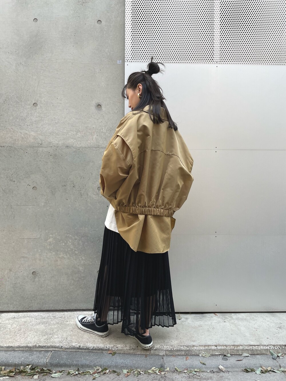 ベージュ系のブルゾン、ブラック系のスカートを着用したレディースの春コーディネートの2枚目の写真