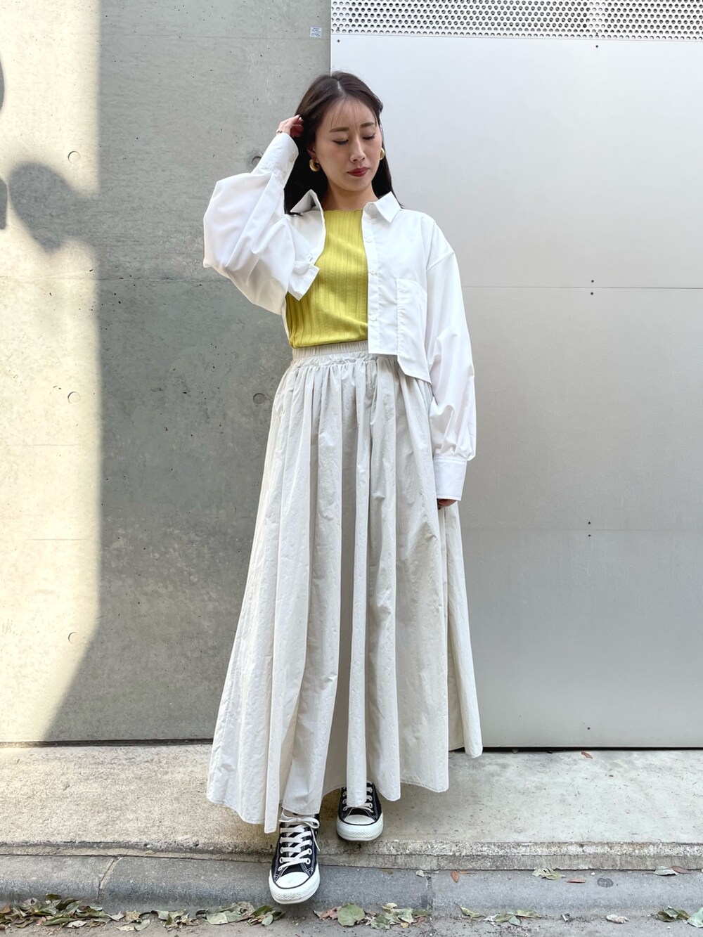 ブラック系のスニーカー、グレー系のスカート、ホワイト系のシャツ/ブラウスを着用したレディースの春コーディネートの2枚目の写真