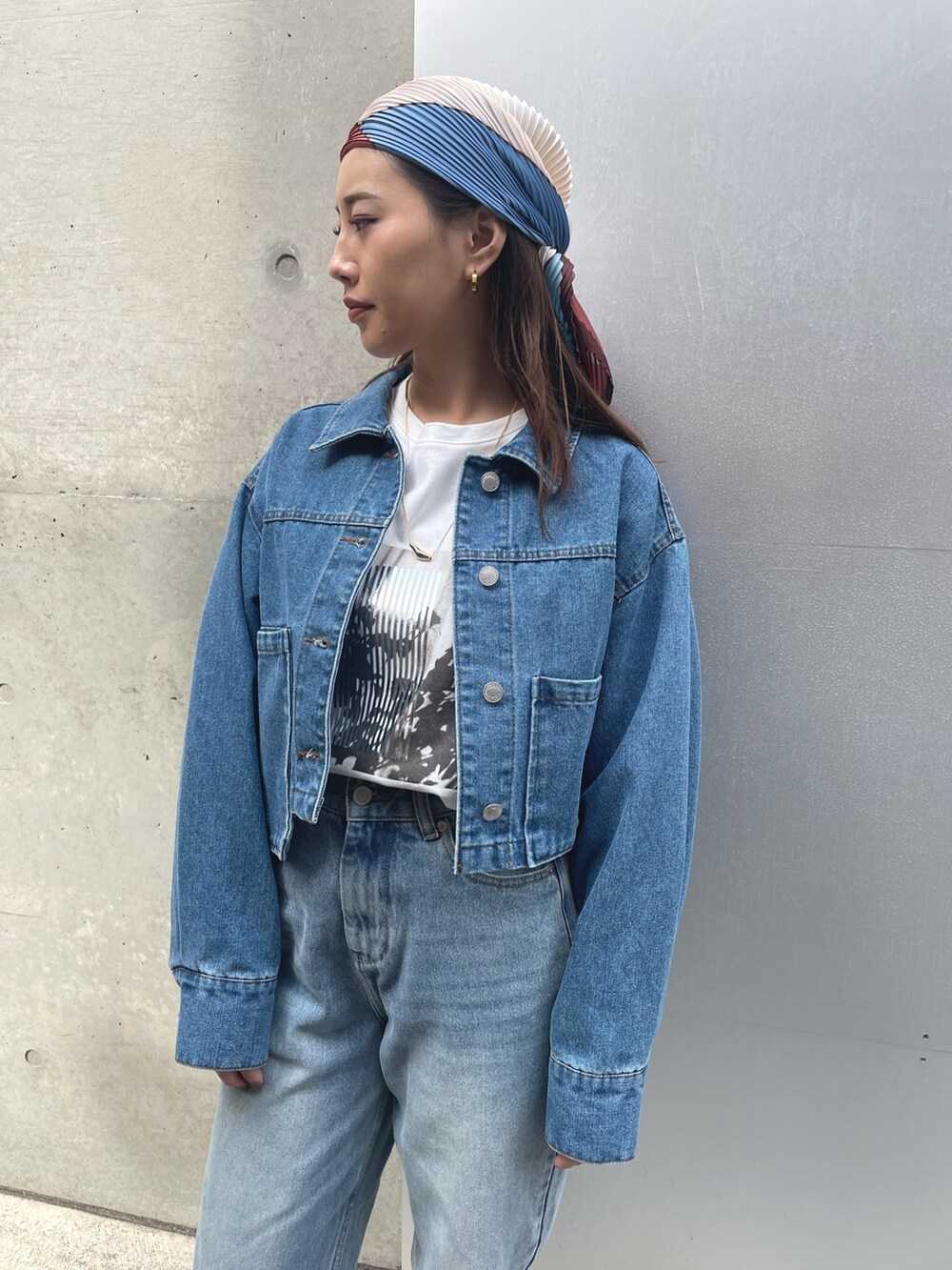 ブルー系のデニムパンツ、ベージュ系のスニーカー、ブルー系のデニムジャケットを着用したレディースの春コーディネートの2枚目の写真