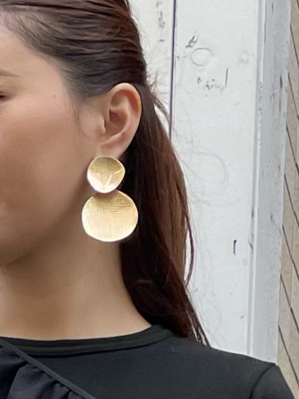 ブルー系のハンドバッグ、ブラック系のワンピース、ゴールド系のピアス（両耳用）を着用したレディースの冬コーディネートの6枚目の写真