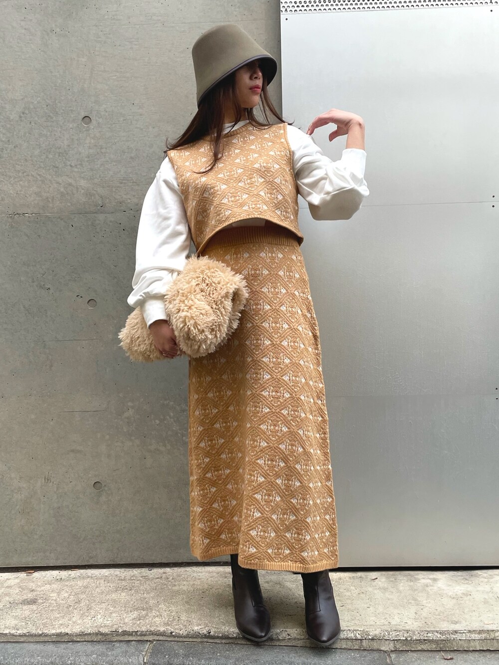 ベージュ系のトートバッグ、ベージュ系のスカート、グリーン系のハットを着用したレディースの冬コーディネートの2枚目の写真