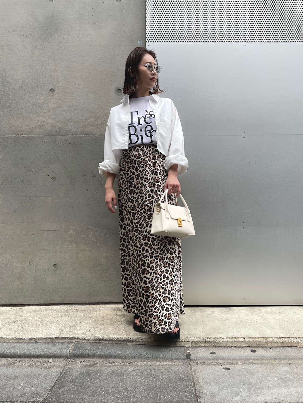 ホワイト系のシャツ/ブラウス、ブラウン系のスカート、ブラック系のサンダルを着用したレディースの春コーディネートの2枚目の写真