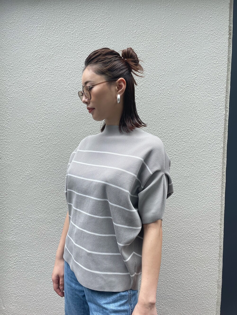 グレー系のTシャツ/カットソー、ブルー系のデニムパンツ、ブラウン系のサングラスを着用したレディースの夏コーディネートの3枚目の写真