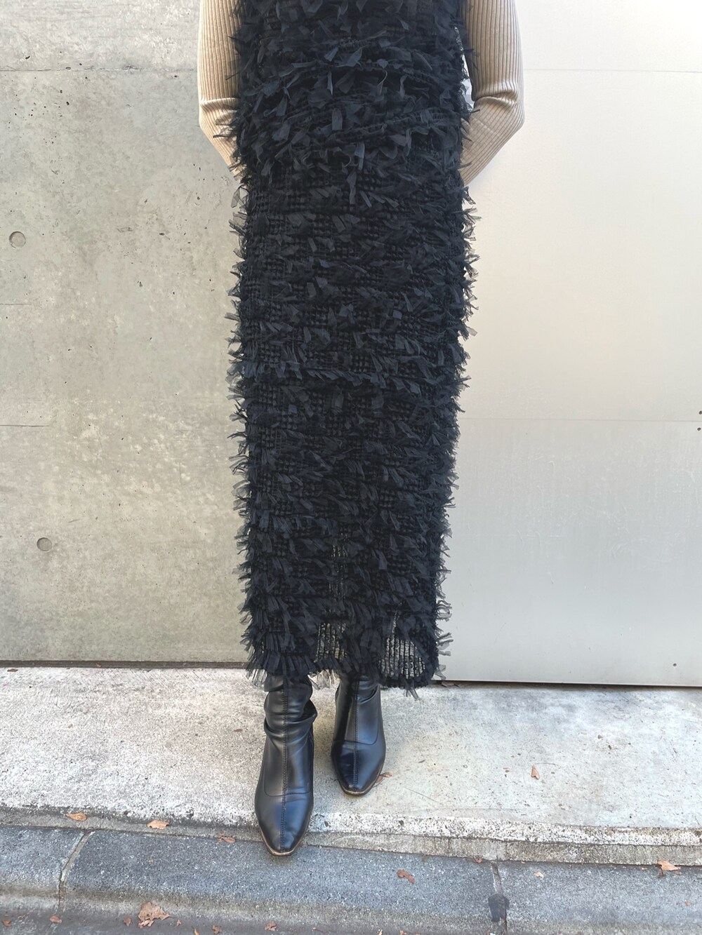 ベージュ系のニット/セーター、ブラック系のベスト、ブラック系のスカートを着用したレディースの冬コーディネートの5枚目の写真