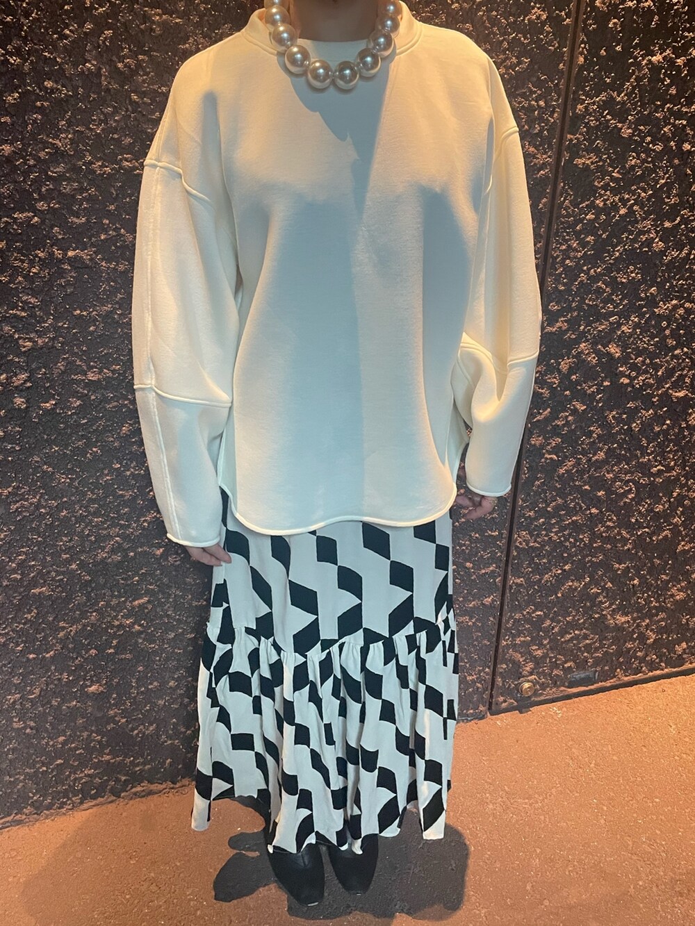 ベージュ系のスカート、ホワイト系のスウェット、その他のネックレスを着用したレディースの秋コーディネートの4枚目の写真