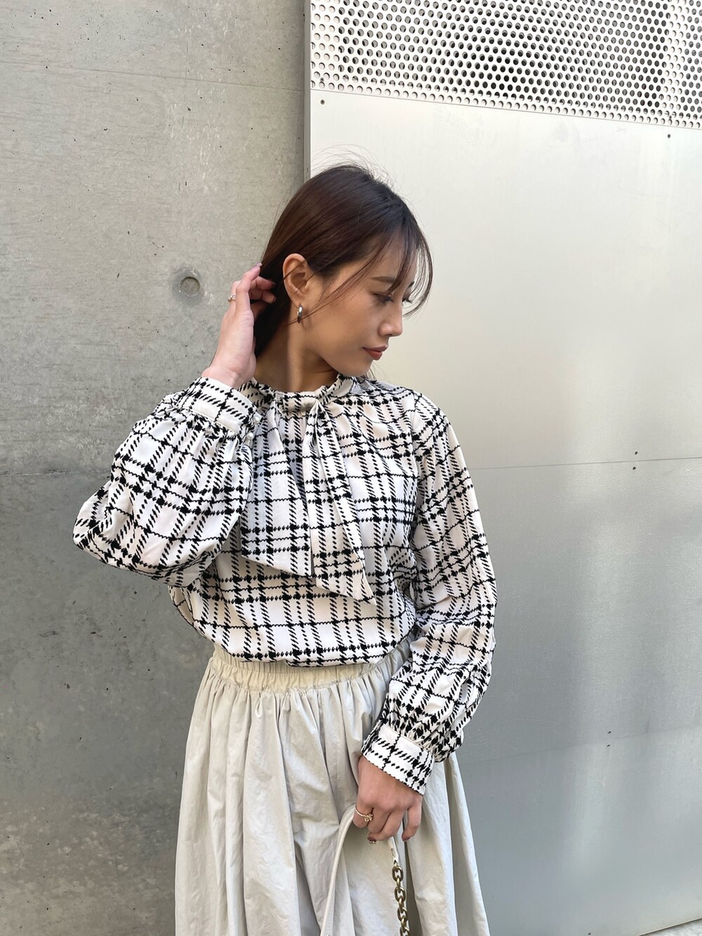 ホワイト系のハンドバッグ、グレー系のスカート、ホワイト系のシャツ/ブラウスを着用したレディースの冬コーディネートの2枚目の写真