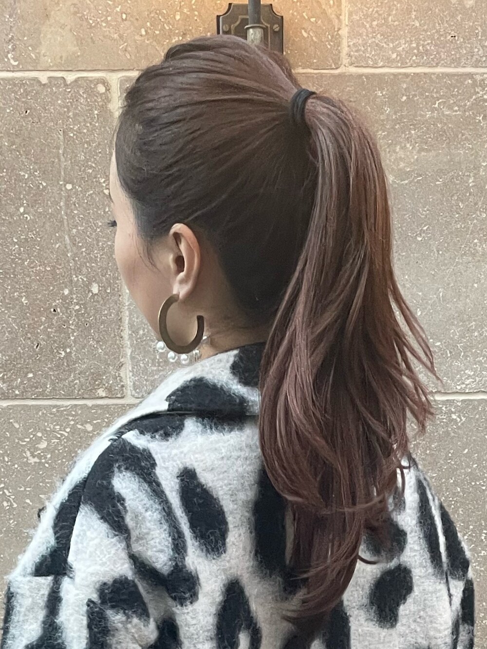 ベージュ系のチェスターコート、ゴールド系のピアス（両耳用）を着用したレディースの秋コーディネートの8枚目の写真