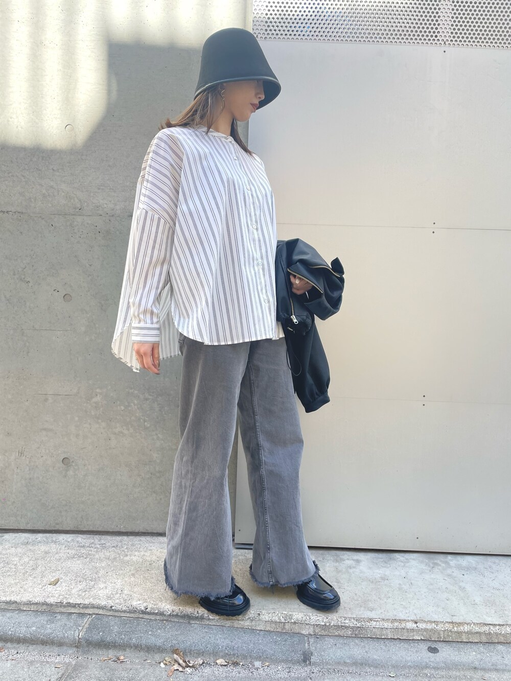 ホワイト系のシャツ/ブラウス、ブラック系のデニムパンツ、ブラック系のブルゾンを着用したレディースの春コーディネートの2枚目の写真