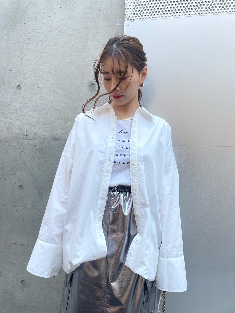 ホワイト系のスニーカー、ホワイト系のバッグ、シルバー系のスカートを着用したレディースの春コーディネートの4枚目の写真