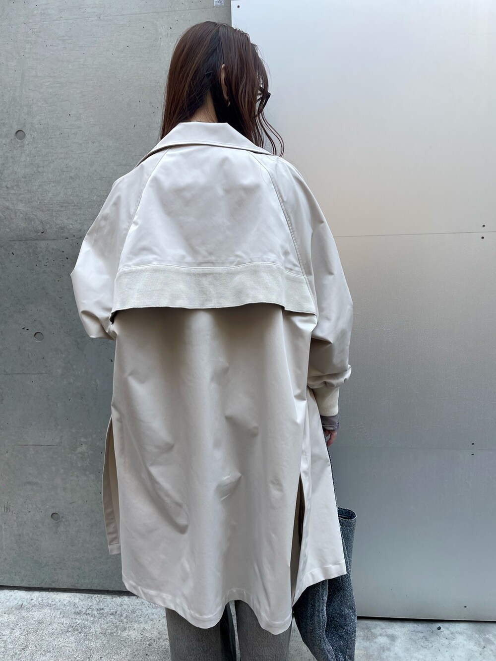 ベージュ系のトレンチコート、ブラック系のデニムパンツ、ホワイト系のスニーカーを着用したレディースの春コーディネートの4枚目の写真