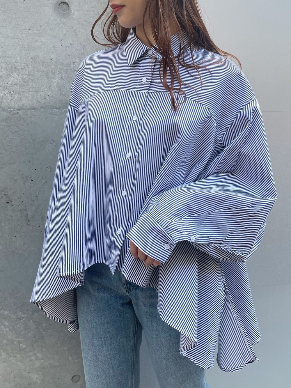 ブルー系のデニムパンツ、ブラック系のローファー、ブラック系のベストを着用したレディースの春コーディネートの7枚目の写真