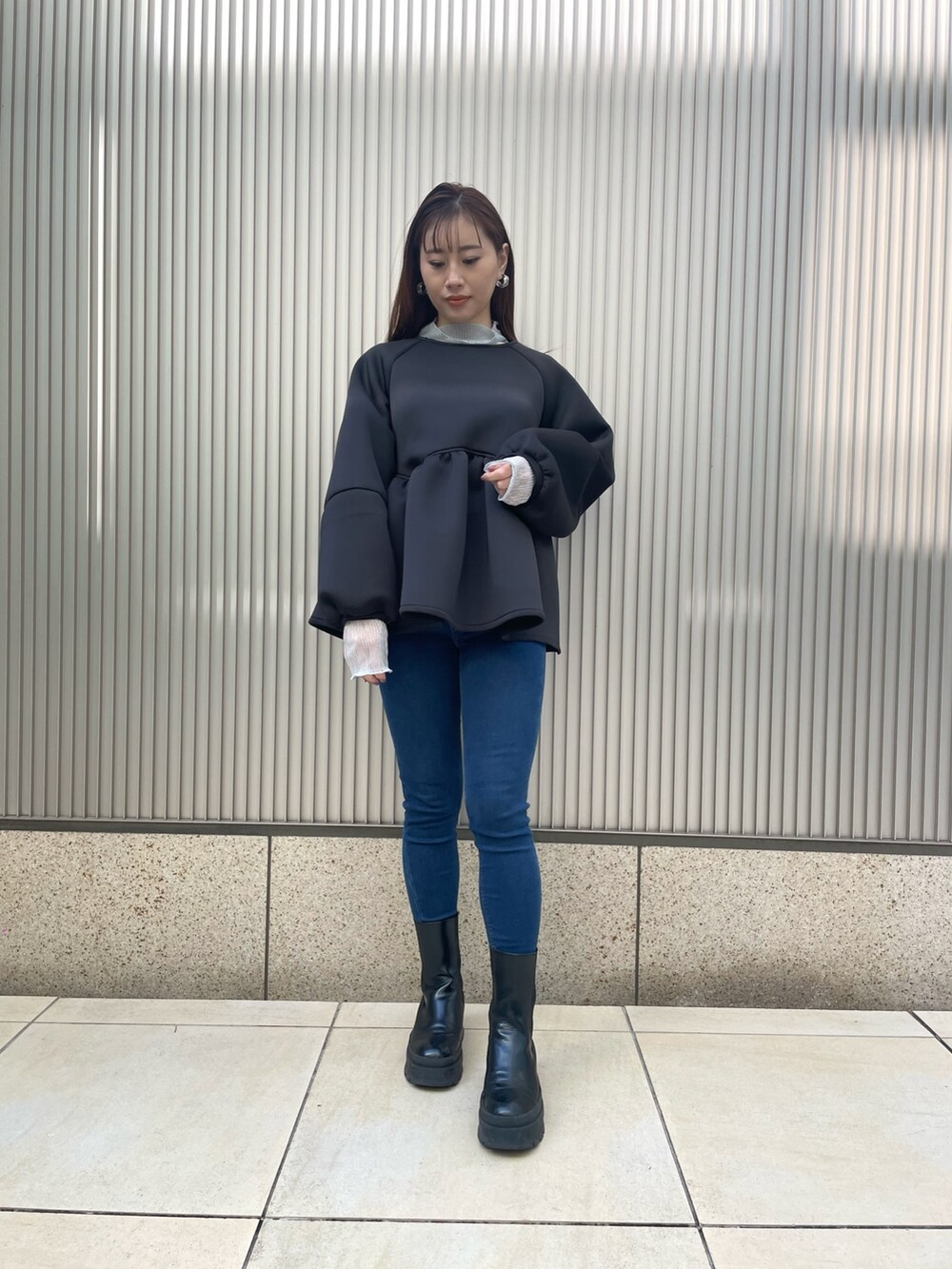 ブルー系のデニムパンツ、ブラック系のブーツ、シルバー系のTシャツ/カットソーを着用したレディースの冬コーディネートの2枚目の写真