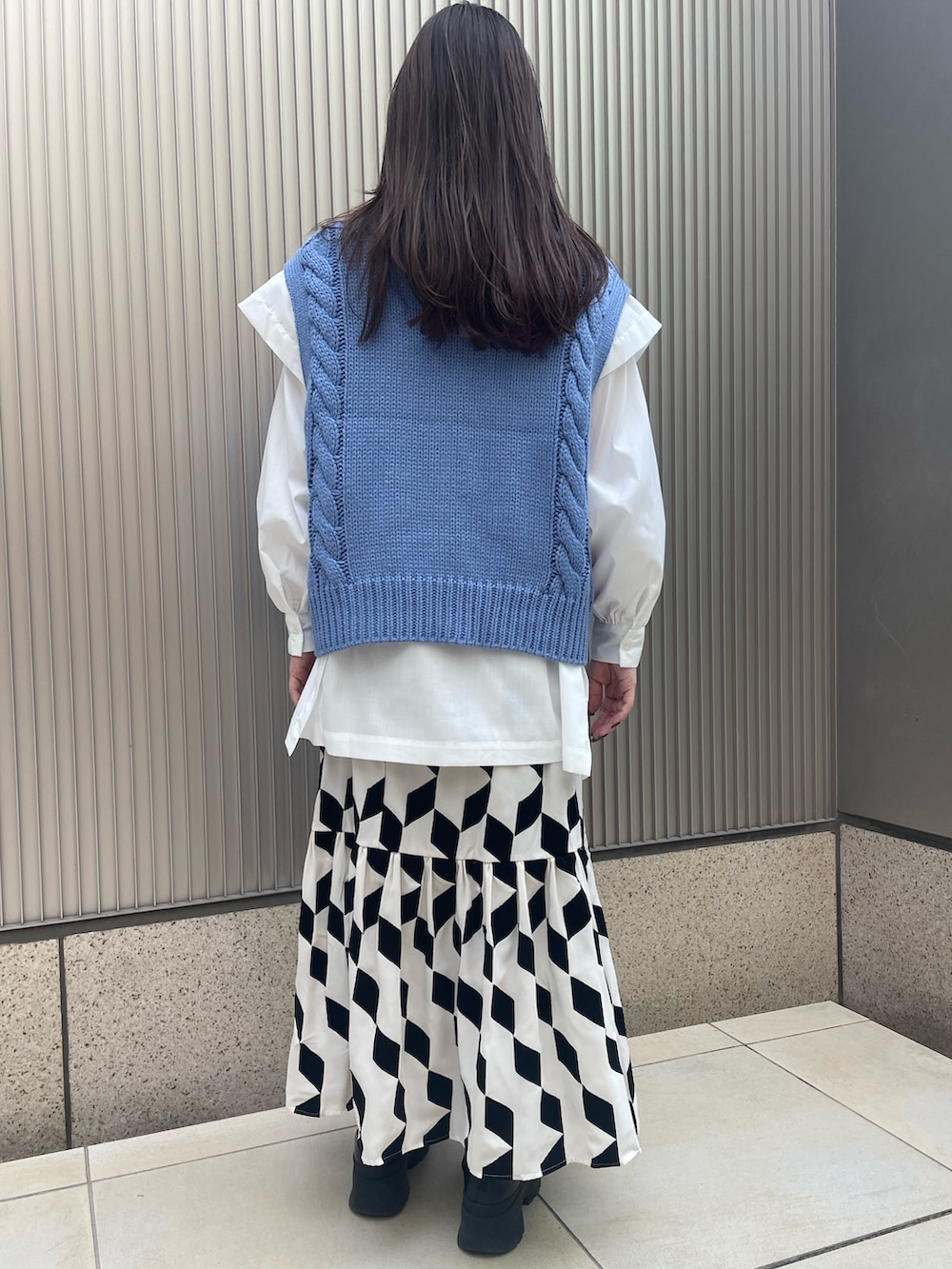 ブラック系のスカート、ブルー系のベスト、ホワイト系のシャツ/ブラウスを着用したレディースの冬コーディネートの5枚目の写真