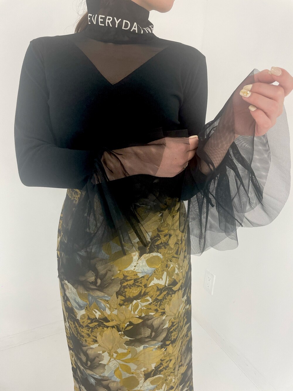 ブラック系のトートバッグ、ホワイト系のスカートを着用したレディースの冬コーディネートの5枚目の写真