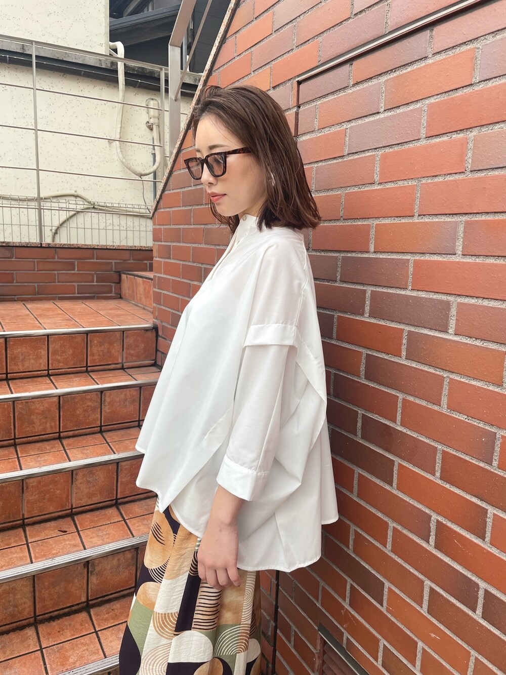 ブラウン系のその他パンツ、ホワイト系のシャツ/ブラウス、ブラック系のサングラスを着用したレディースの春コーディネートの3枚目の写真