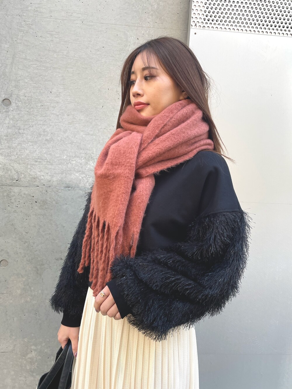 ホワイト系のスカート、ブラック系のスウェット、ベージュ系のトートバッグを着用したレディースの冬コーディネートの3枚目の写真