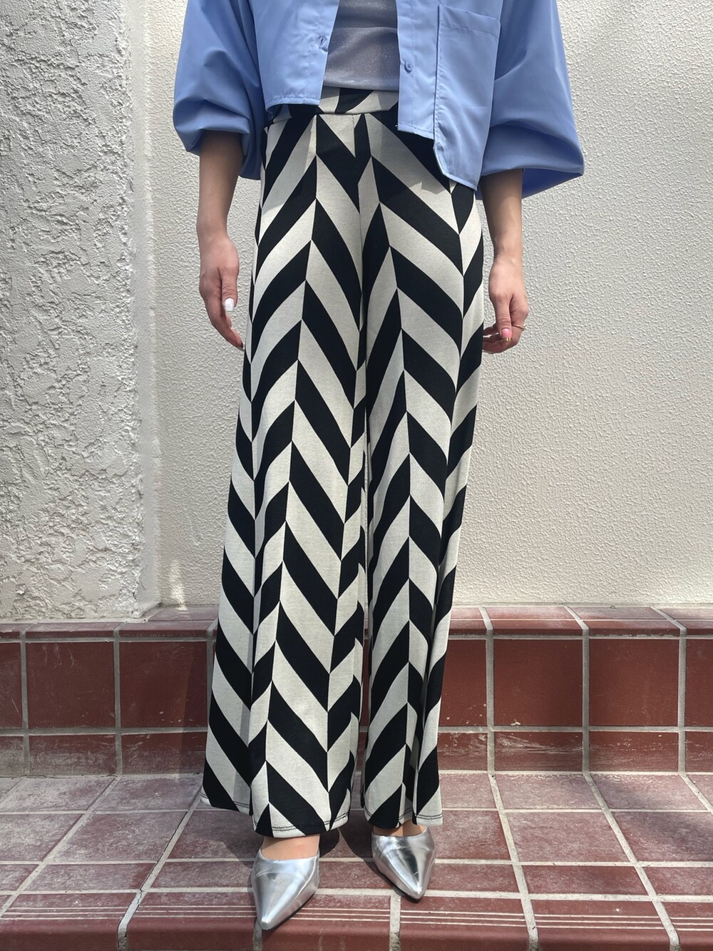 ブルー系のシャツ/ブラウス、ブラック系のその他パンツ、ブラック系のハットを着用したレディースの春コーディネートの3枚目の写真