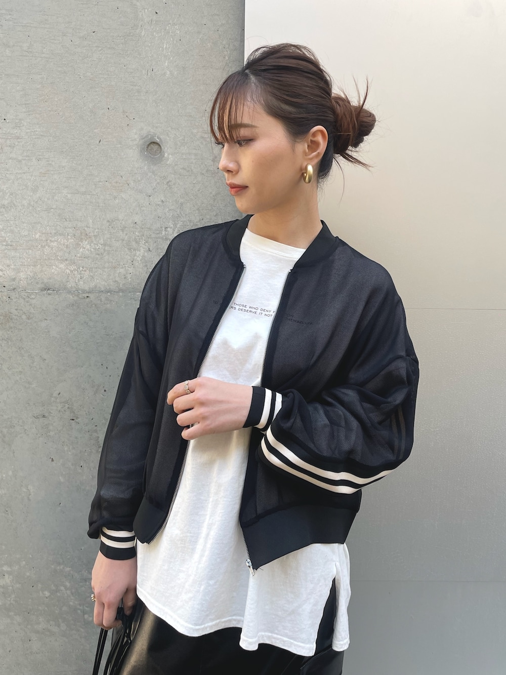 ブラック系のブルゾン、ブラック系のショルダーバッグ、ブラック系のスカートを着用したレディースの春コーディネートの3枚目の写真