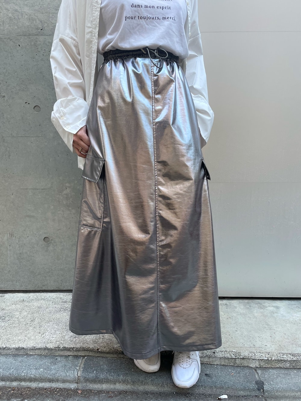 ホワイト系のハンドバッグ、ホワイト系のスニーカー、シルバー系のスカートを着用したレディースの春コーディネートの7枚目の写真