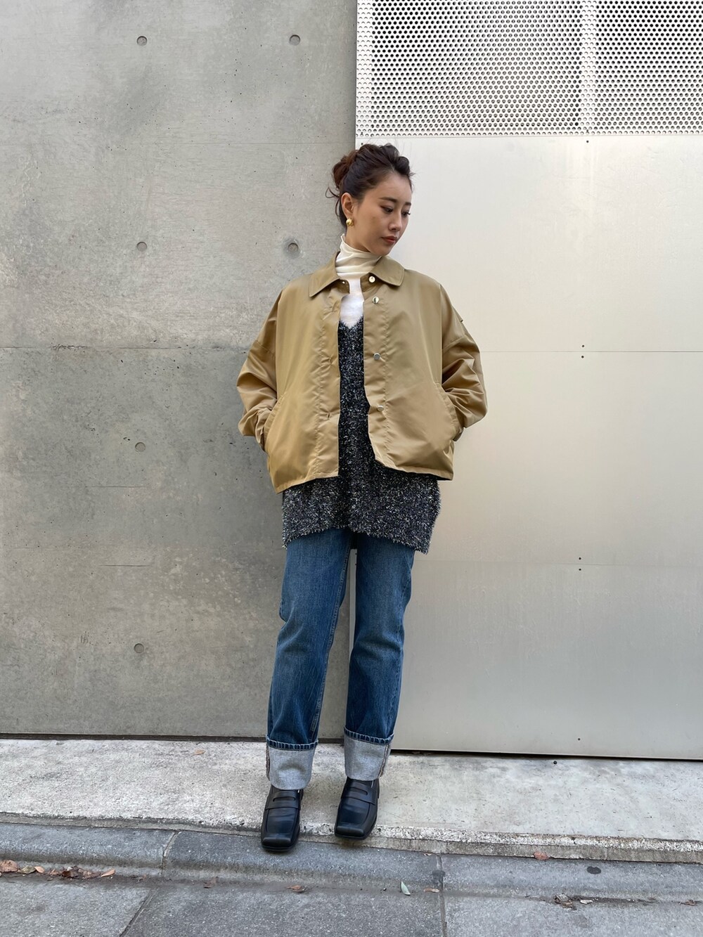 ブラック系のベスト、ベージュ系のブルゾン、ホワイト系のTシャツ/カットソーを着用したレディースの冬コーディネートの2枚目の写真