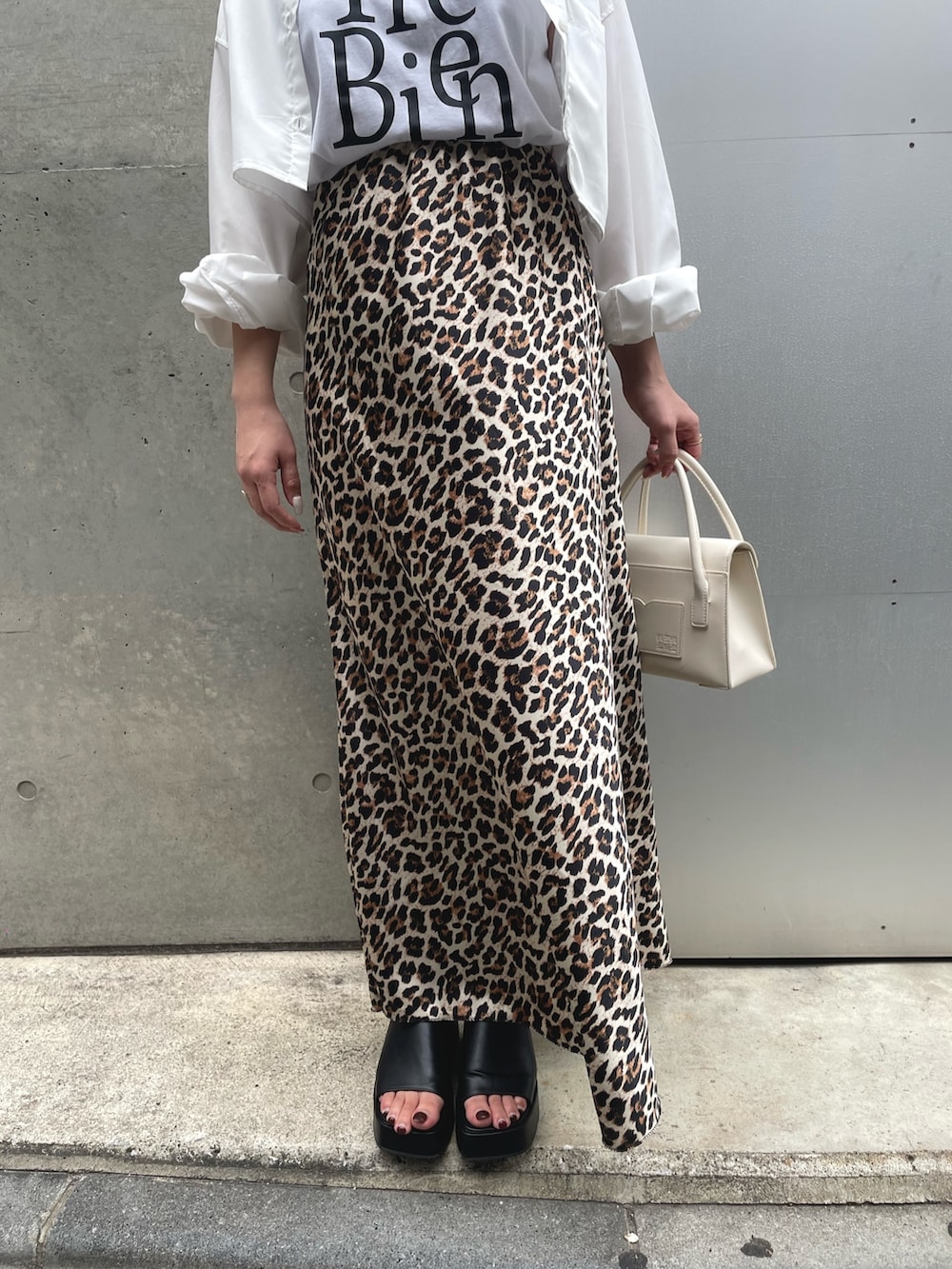 ホワイト系のシャツ/ブラウス、ブラウン系のスカート、ブラック系のサンダルを着用したレディースの春コーディネートの5枚目の写真