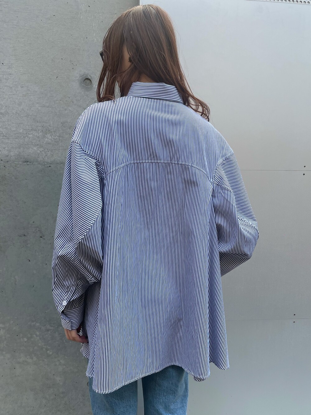 ブルー系のデニムパンツ、ブラック系のローファー、ブラック系のベストを着用したレディースの春コーディネートの9枚目の写真