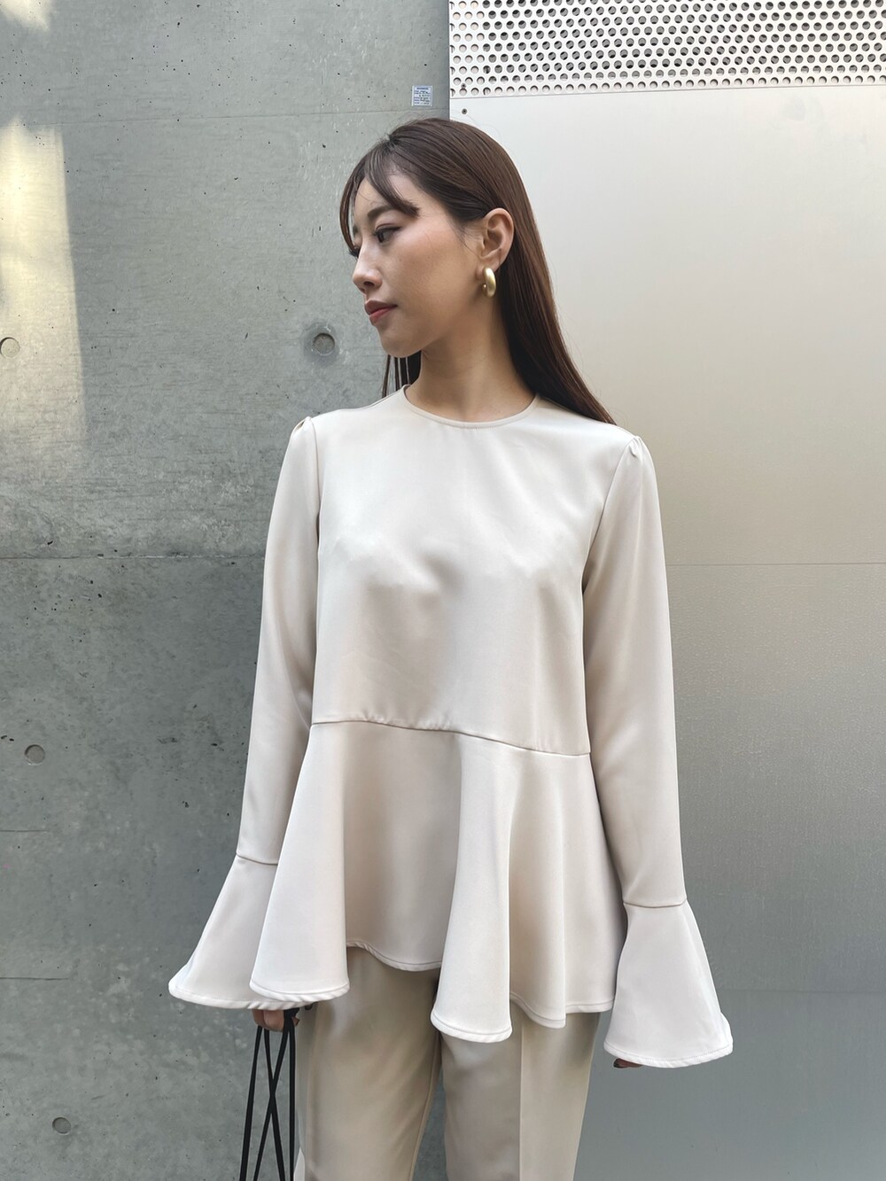 ベージュ系のシャツ/ブラウス、ブラック系のショルダーバッグ、ベージュ系のその他パンツを着用したレディースの春コーディネートの3枚目の写真