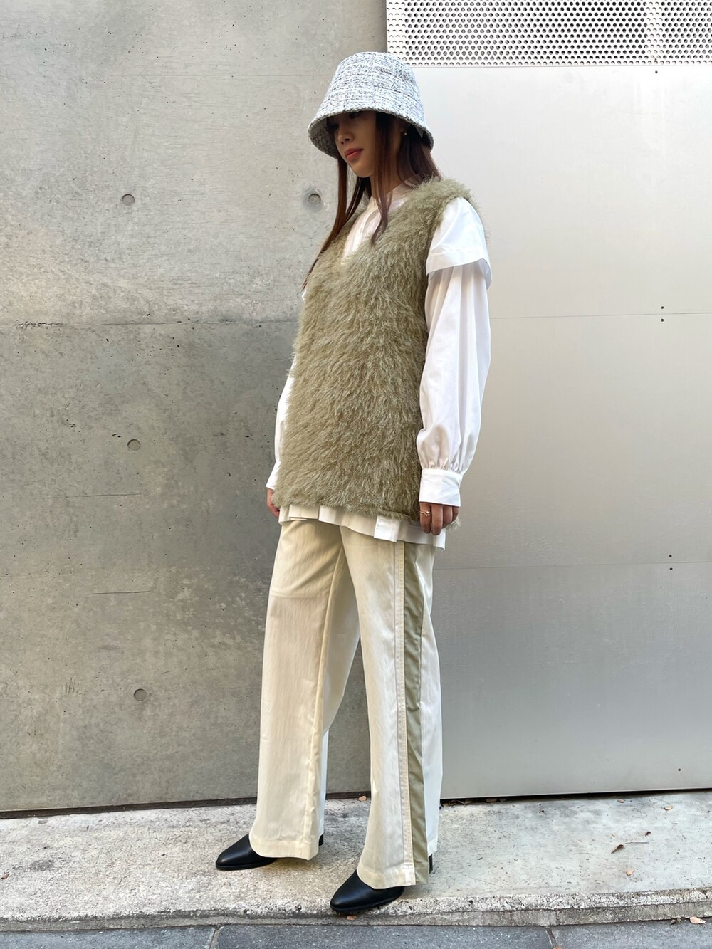 グリーン系のベスト、ホワイト系のシャツ/ブラウス、ホワイト系のその他パンツを着用したレディースの冬コーディネートの2枚目の写真