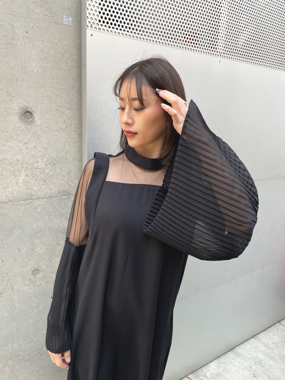 ブラック系のワンピース、シルバー系のパンプスを着用したレディースの春コーディネートの3枚目の写真