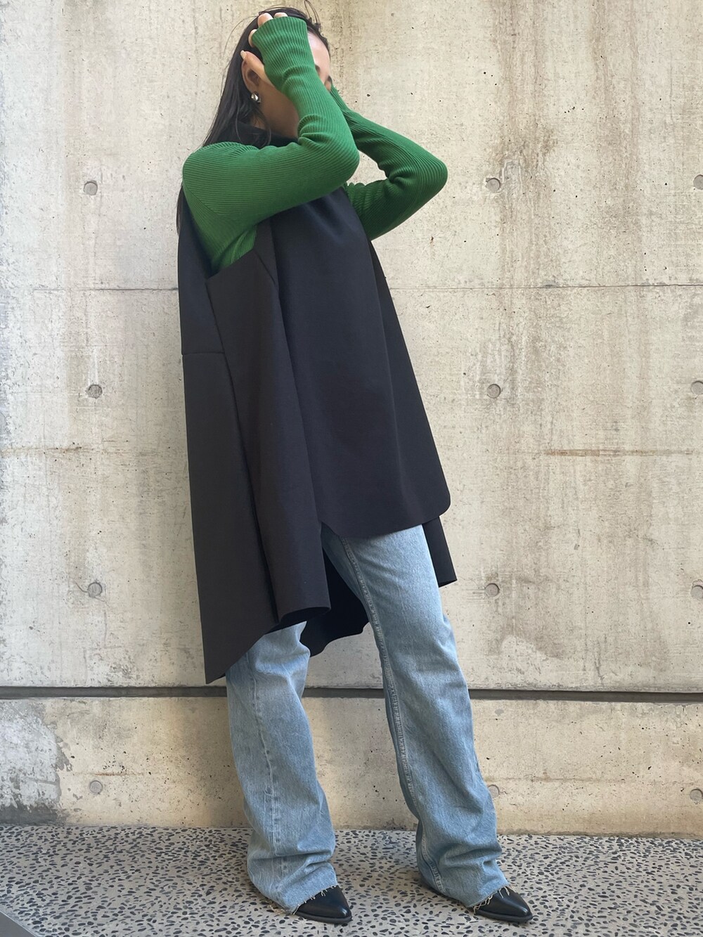 ブラック系のベスト、グリーン系のニット/セーターを着用したレディースの冬コーディネートの3枚目の写真