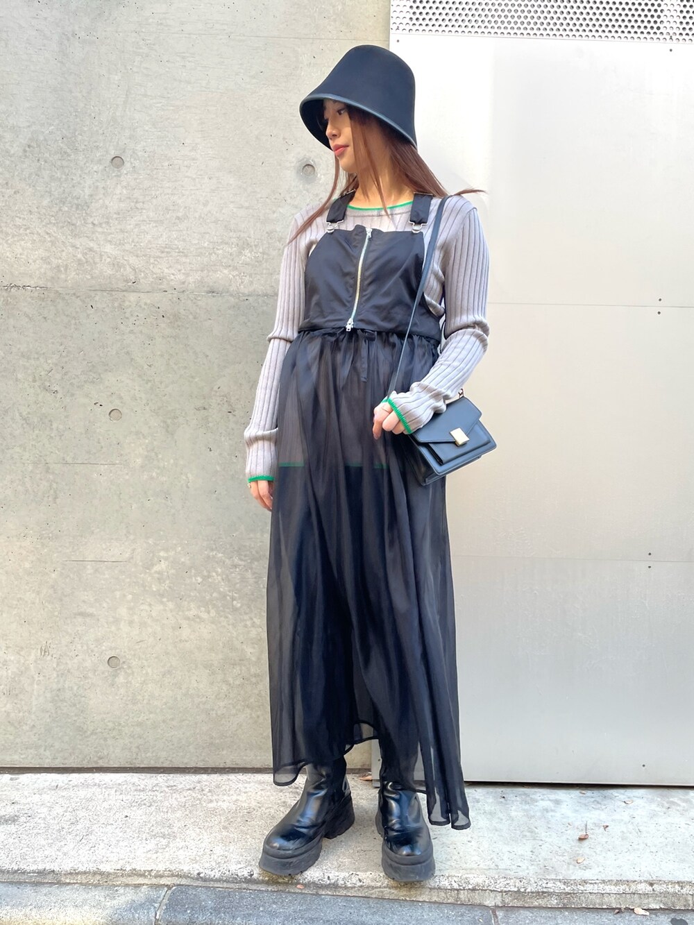 ブルー系のパンツ、ブラック系のワンピース、グレー系のニット/セーターを着用したレディースの冬コーディネートの2枚目の写真