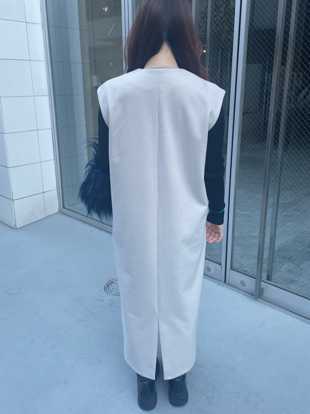 ブルー系のハンドバッグ、ブラック系のニット/セーター、ホワイト系のワンピースを着用したレディースの秋コーディネートの5枚目の写真