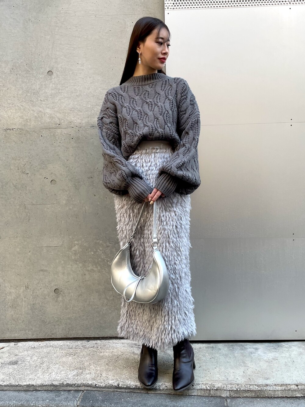 グレー系のニット/セーター、シルバー系のショルダーバッグ、グレー系のスカートを着用したレディースの冬コーディネートの4枚目の写真
