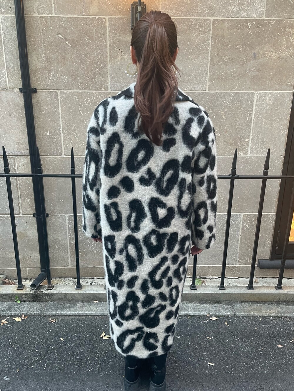 ベージュ系のチェスターコート、ゴールド系のピアス（両耳用）を着用したレディースの秋コーディネートの4枚目の写真