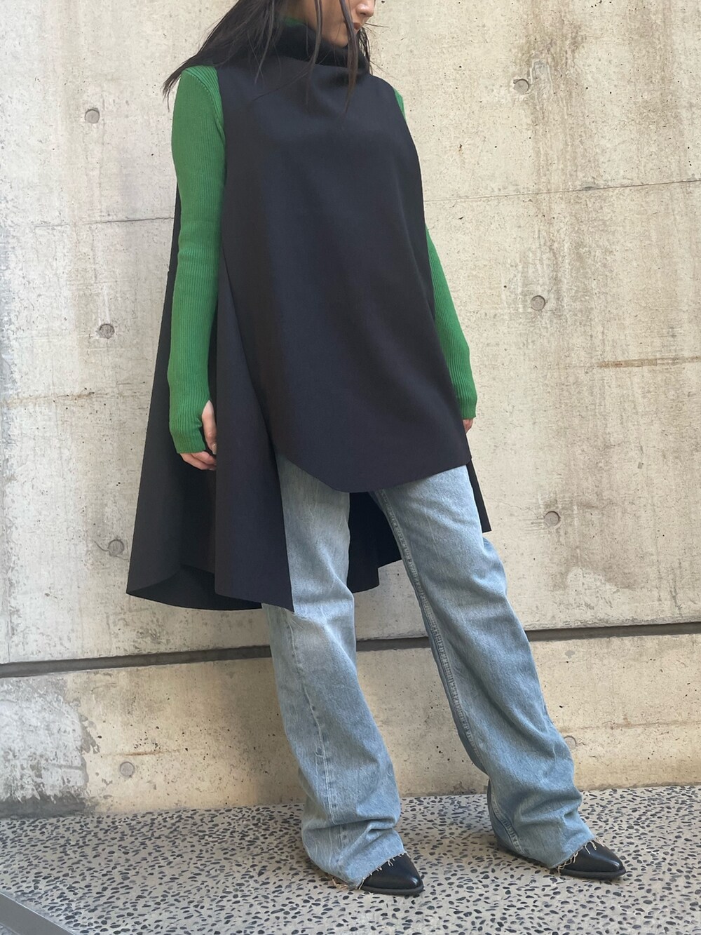 ブラック系のベスト、グリーン系のニット/セーターを着用したレディースの冬コーディネートの4枚目の写真