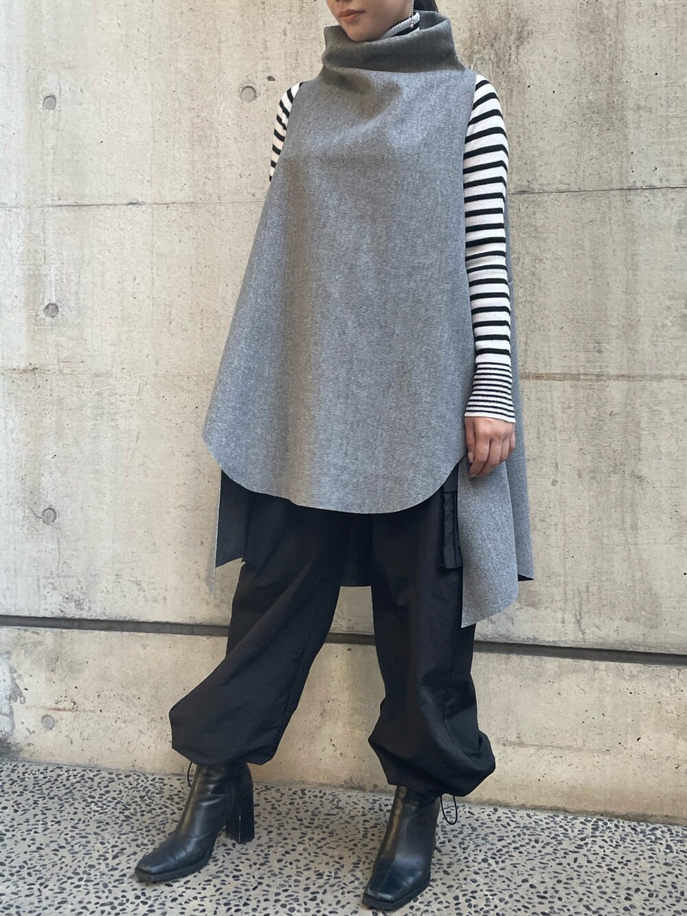 グレー系のベスト、ホワイト系のニット/セーターを着用したレディースの秋コーディネートの7枚目の写真