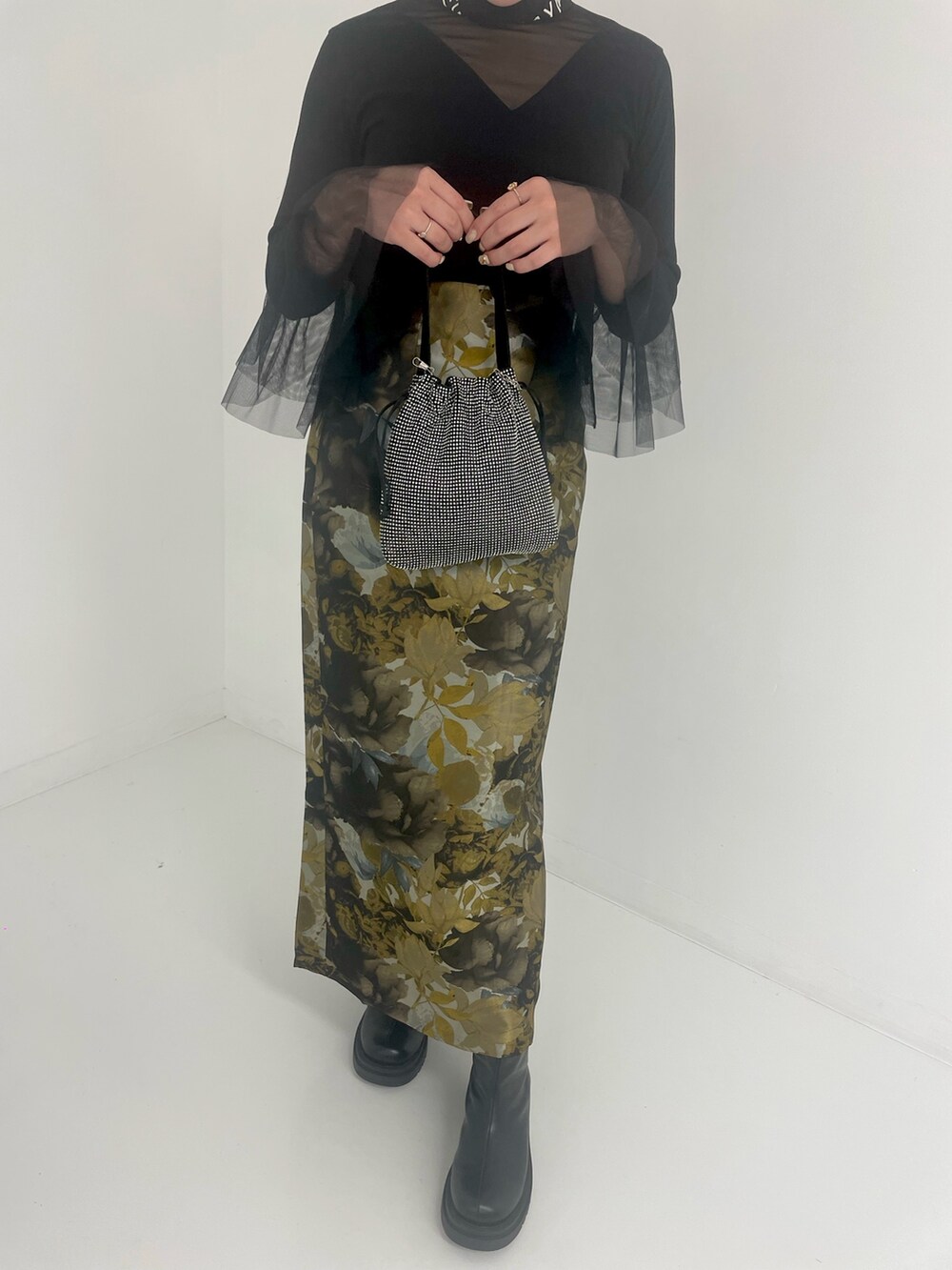 ブラック系のトートバッグ、ホワイト系のスカートを着用したレディースの冬コーディネートの4枚目の写真