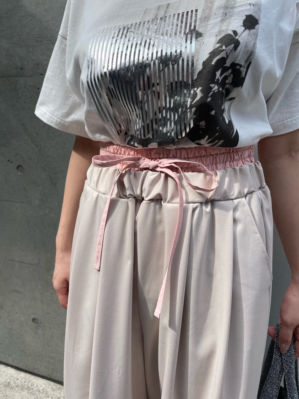 ベージュ系のその他パンツ、シルバー系のトートバッグ、シルバー系のTシャツ/カットソーを着用したレディースの春コーディネートの4枚目の写真