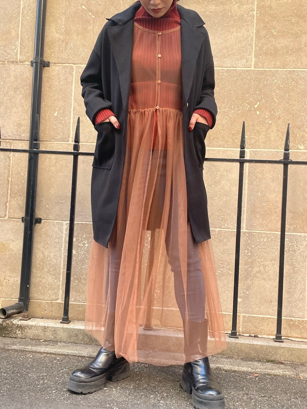 ベージュ系のワンピース、レッド系のニット/セーター、ブラック系のその他アウターを着用したレディースの秋コーディネートの3枚目の写真