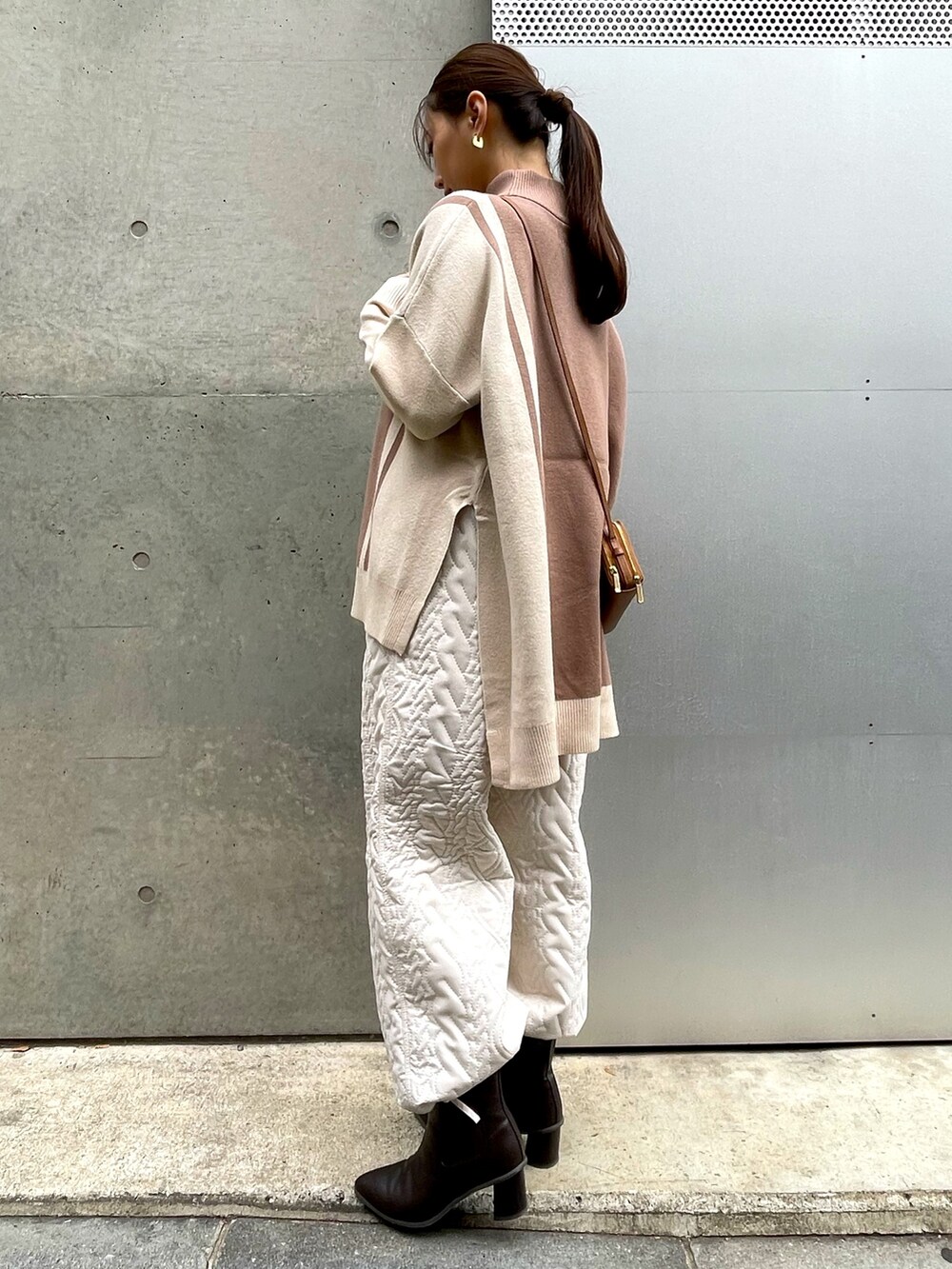 ブラウン系のショルダーバッグ、ベージュ系のニット/セーター、ホワイト系のその他パンツを着用したレディースの冬コーディネートの3枚目の写真