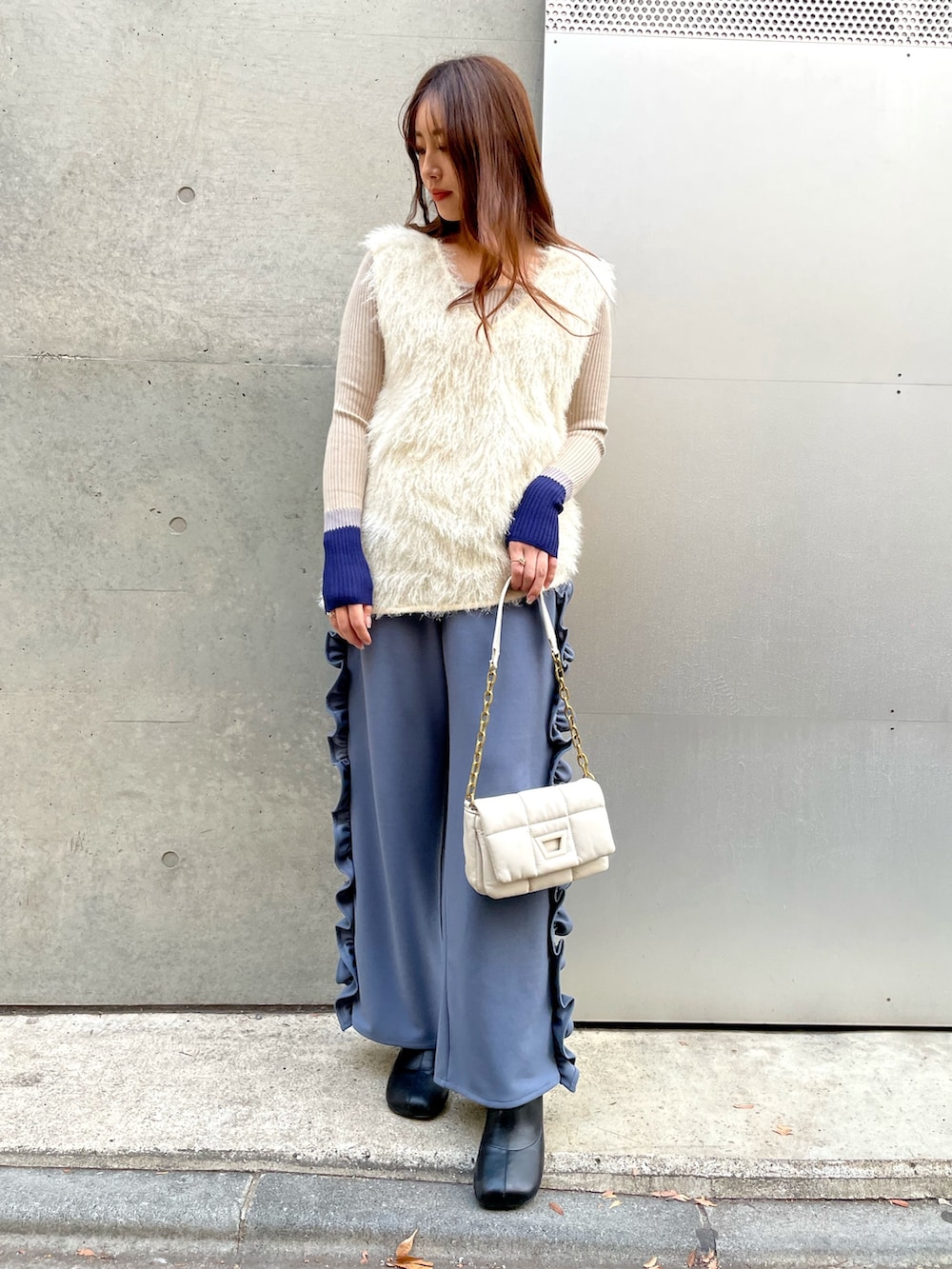 ブルー系のその他パンツ、ベージュ系のニット/セーター、ホワイト系のベストを着用したレディースの冬コーディネートの2枚目の写真