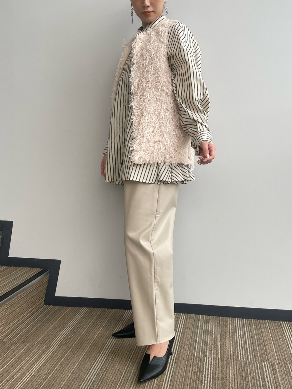 ベージュ系のベストを着用したレディースの冬コーディネートの3枚目の写真